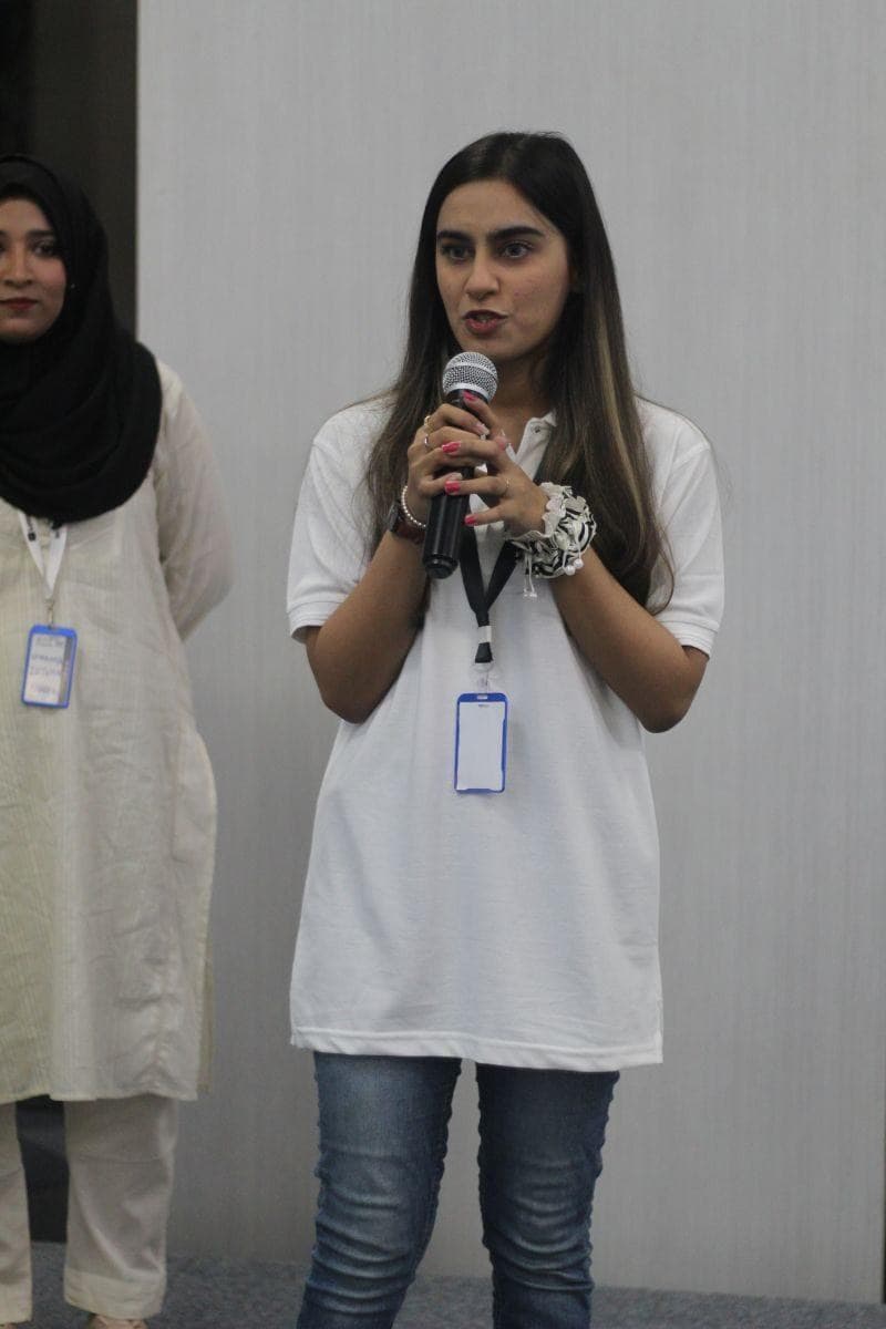 Lalain speaking into a microphone at the first ADPList meetup in her city, her co-host beside her