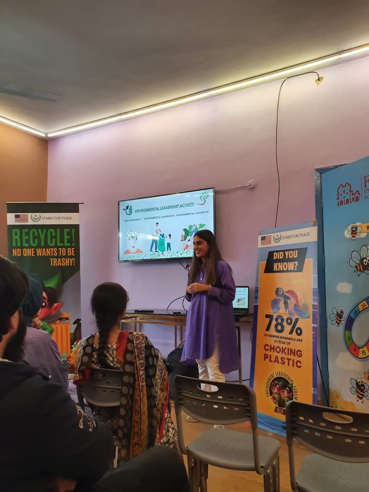 Lalain presenting beside recycling banners