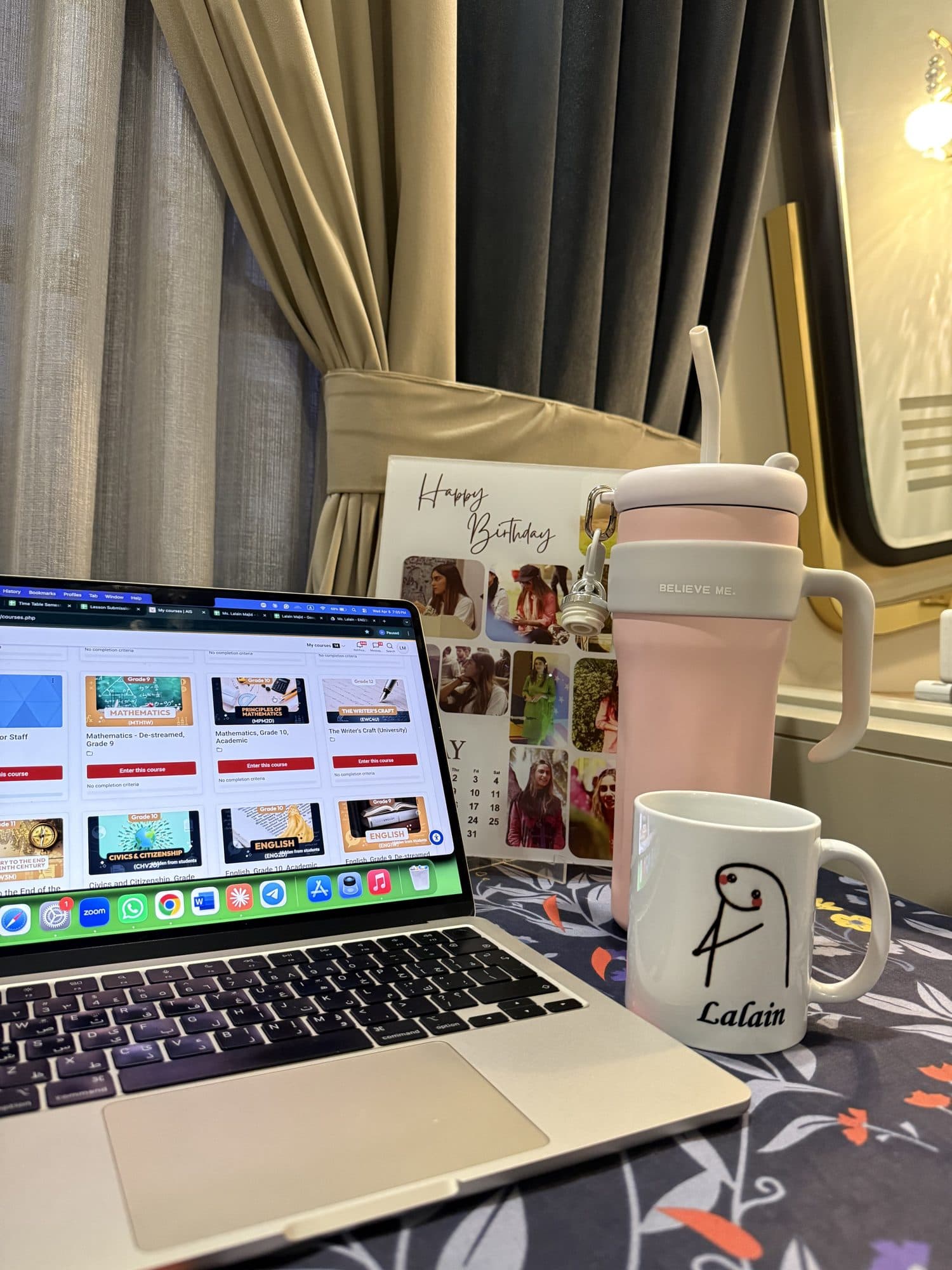 Lalain's desk: her laptop, a mug with her name on it and a birthday calendar