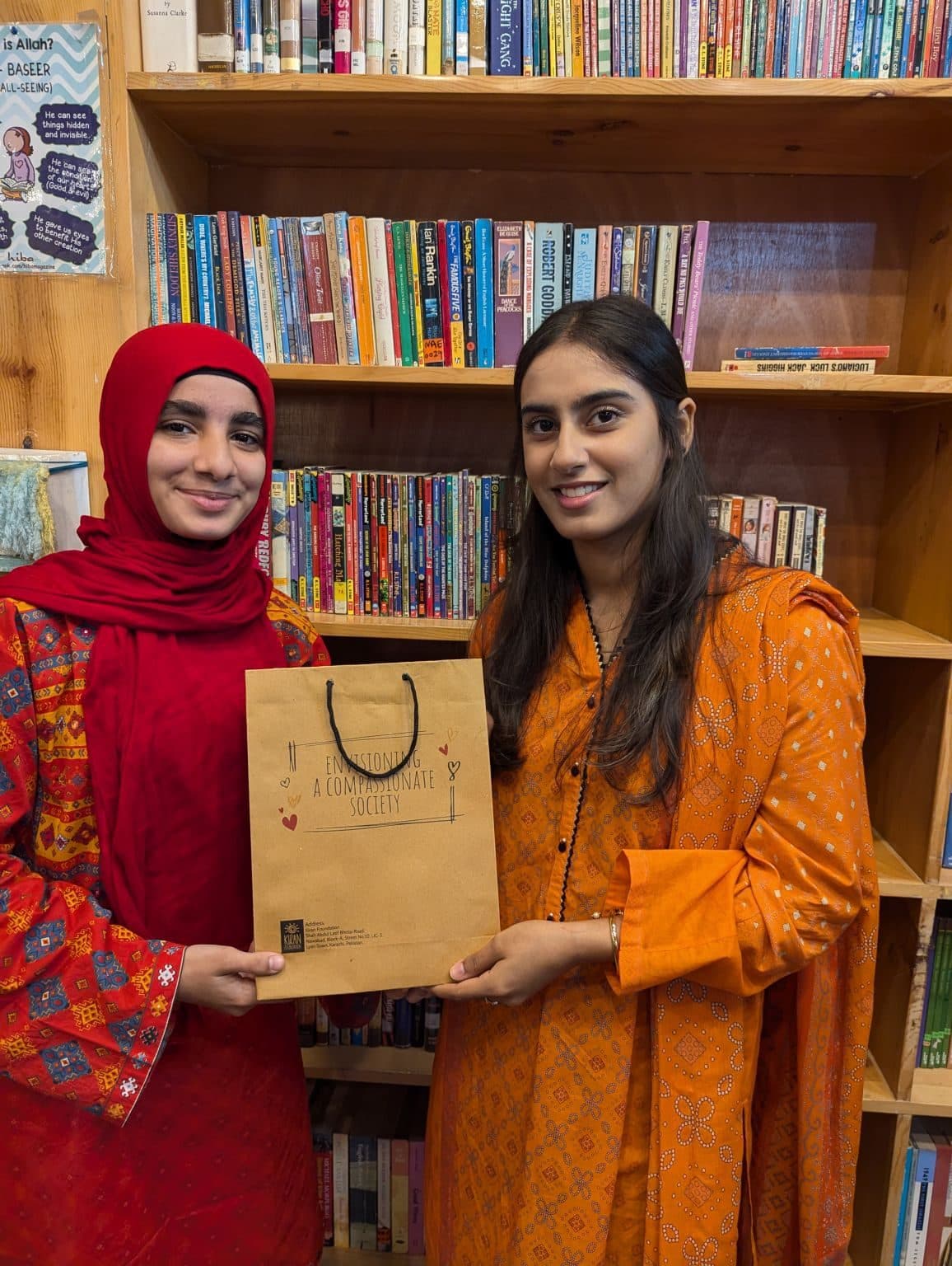 Lalain handing a gift bag to a participant in a library