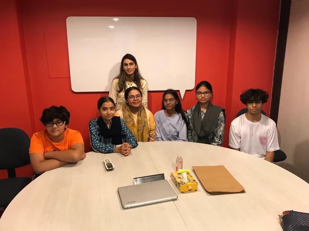 Lalain with a small group of teenagers around a round table